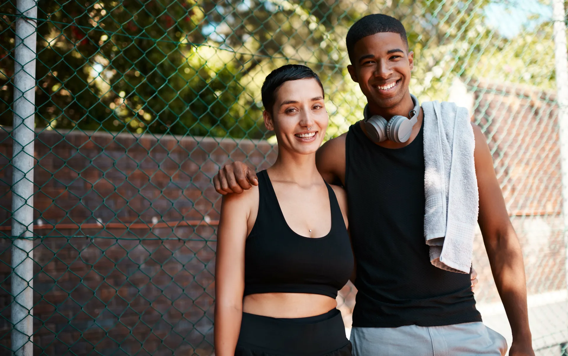 athletic woman and man posing in urban setting utc